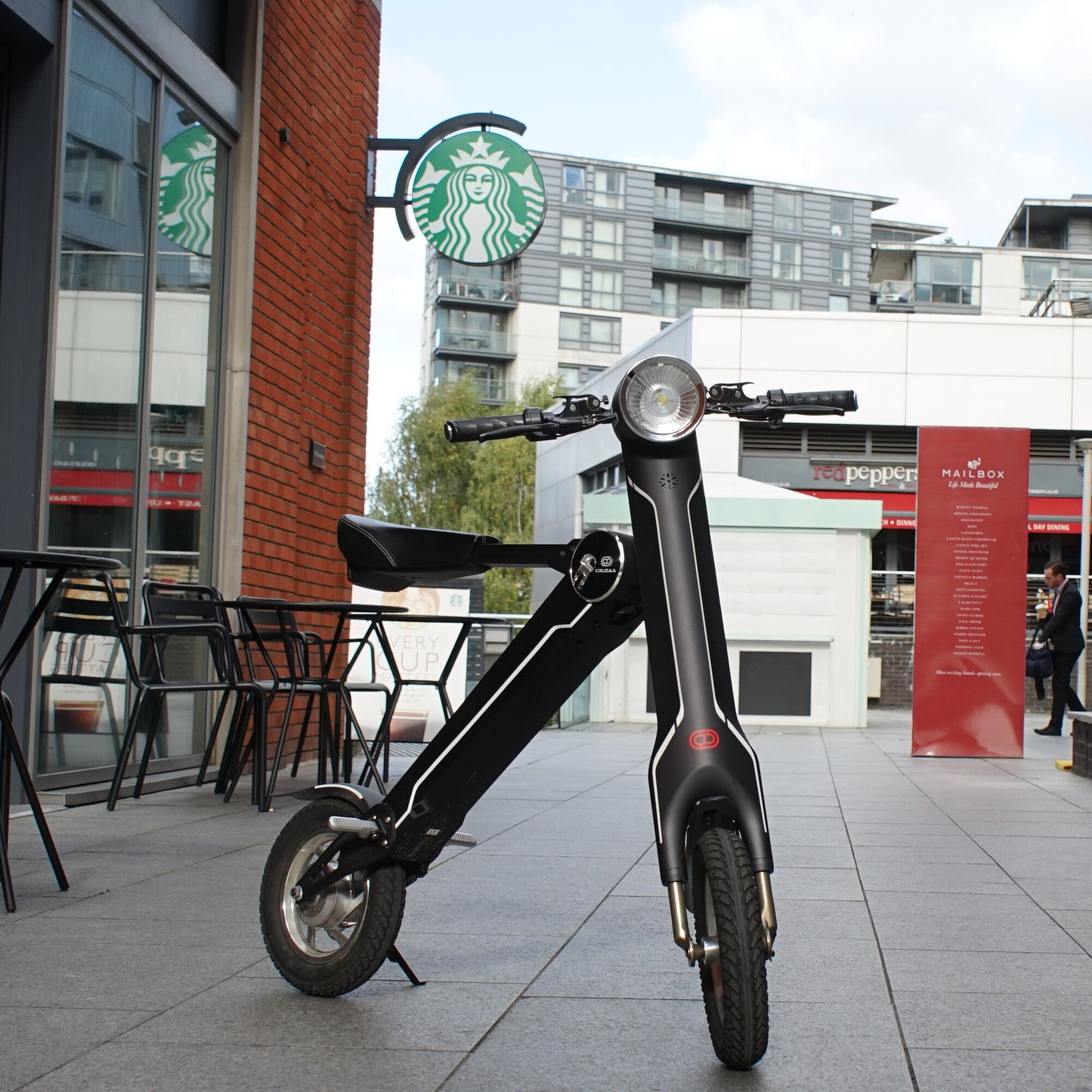 Cruzaa E-Scooter Pro Electric Scooter Carbon Black outside cafe