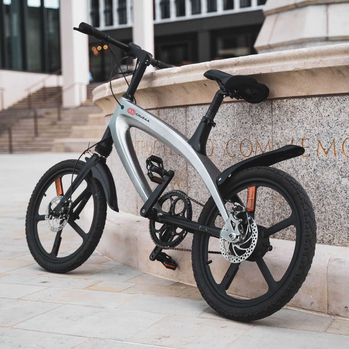 Cruzaa Carbon Black Electric Bike Resting On Wall